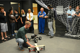Students demonstrating a quadrotor experiment to astronaut